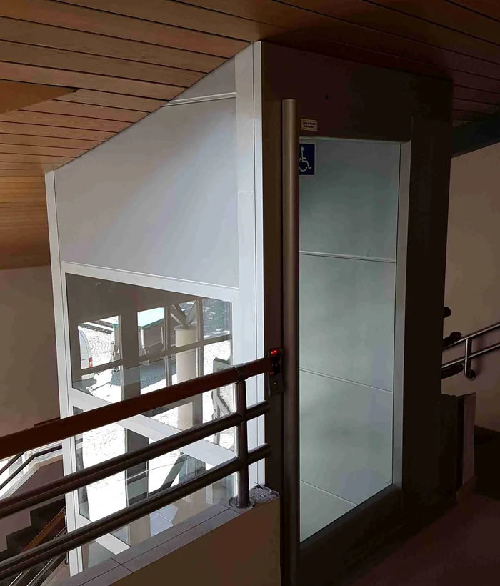 Plattformlift in einer Waldkraiburger Schule mit Spindelantrieb im Glasschacht