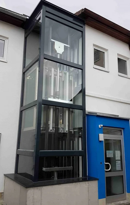 Verglaster Außenaufzug an einem Gebäude